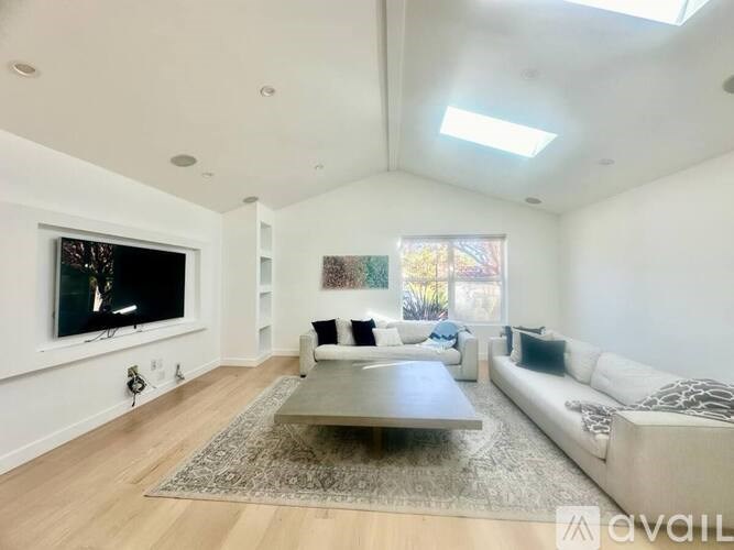 A living room with a television, a couch, and a coffee table.