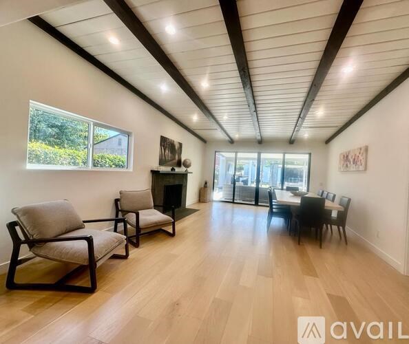 A living room with a fireplace and a dining table.
