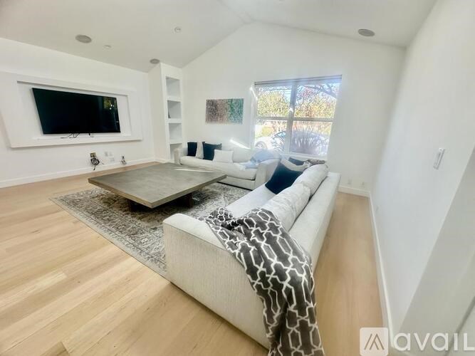 A living room with a couch, coffee table, and television.