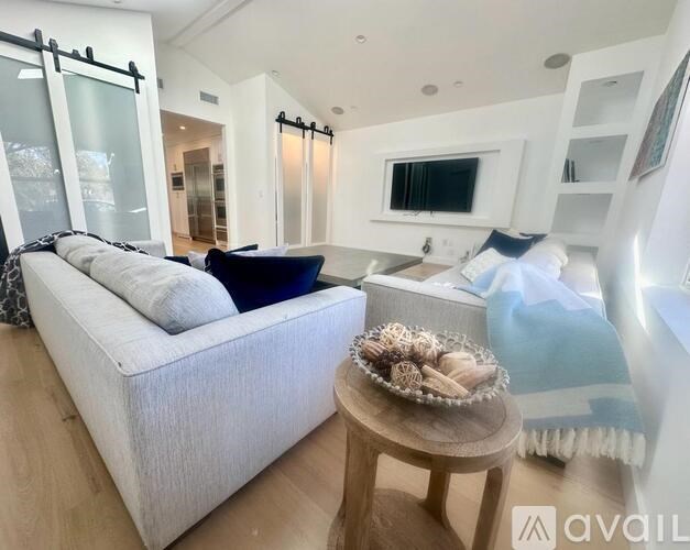 A living room with a white couch and a wooden table.