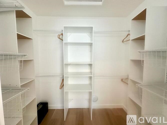 A white closet with a hanger and a white shelf.