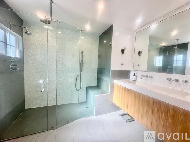 A modern bathroom with a walk-in shower and double sinks.