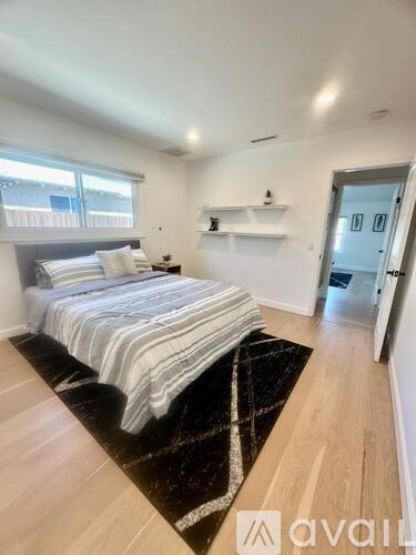 A bedroom with a bed, a rug, and a door.