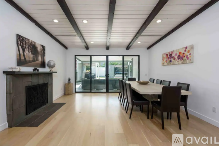 A modern dining room with a fireplace and a large painting on the wall.