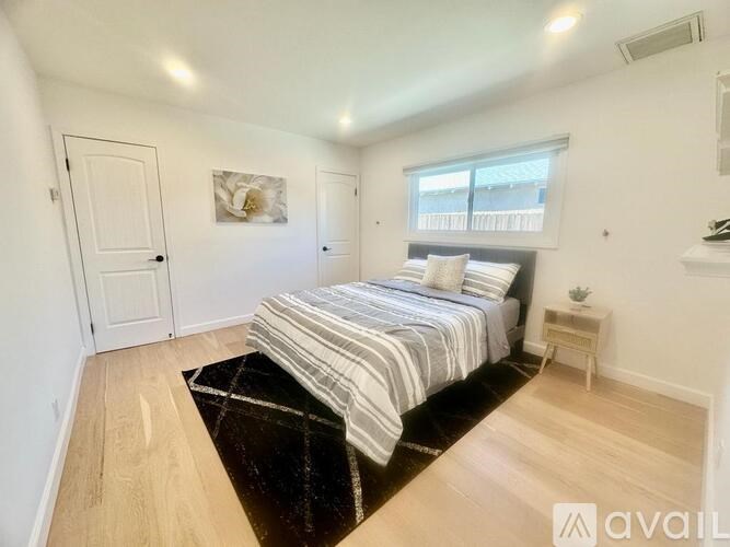 A bedroom with a large bed and a small table.