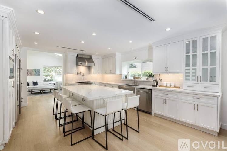 A modern kitchen with white cabinets and a large island.