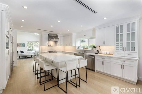 A modern kitchen with white cabinets and a large island.