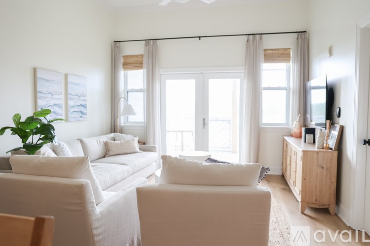 A living room with a white couch and a wooden cabinet.