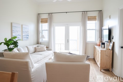 A living room with a white couch and a wooden cabinet.