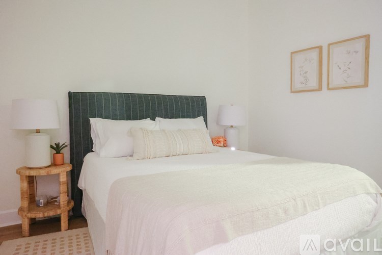 A bed with a white comforter and a green headboard is in the image.