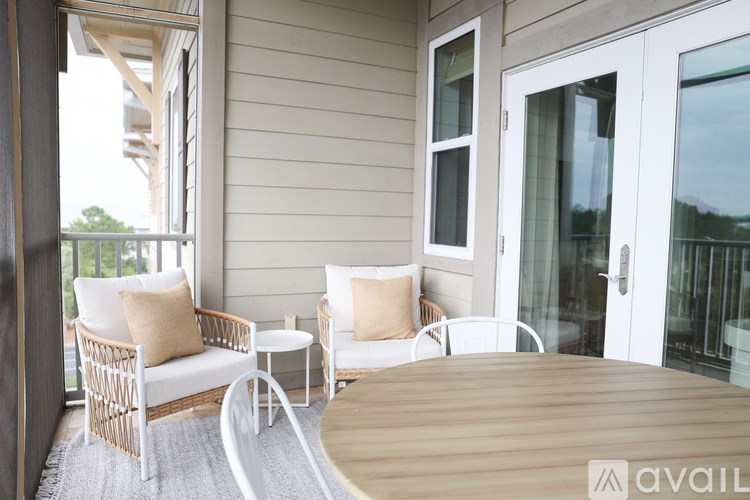 A patio with a white chair and a white table with a cushion on it.