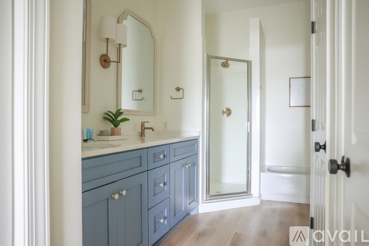 A bathroom with a sink, mirror, and a glass shower door.