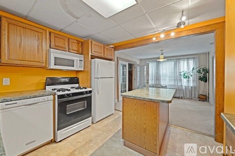 A kitchen with wooden cabinets and white appliances.