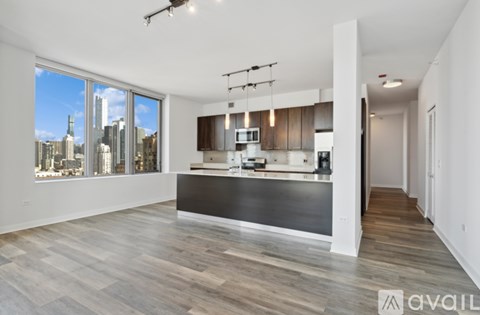 A spacious kitchen and living room with a view of the city skyline.