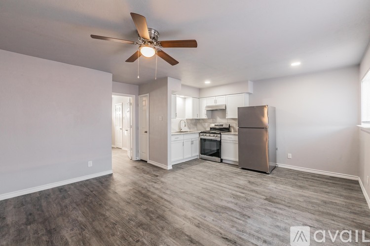 A spacious kitchen with a fan and a refrigerator.