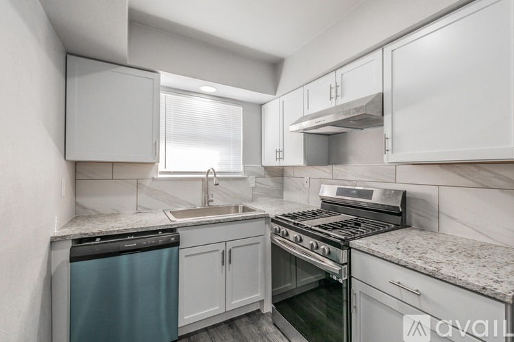 A modern kitchen with white cabinets and stainless steel appliances.