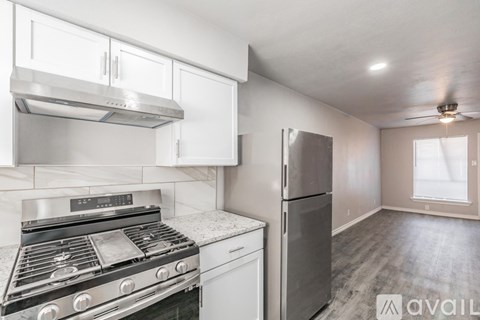 A kitchen with a stove, refrigerator, and cabinets.