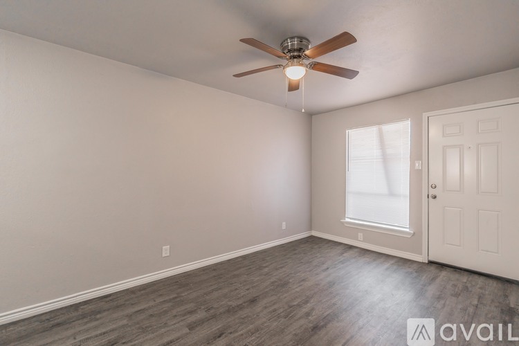 A room with a ceiling fan and a door.