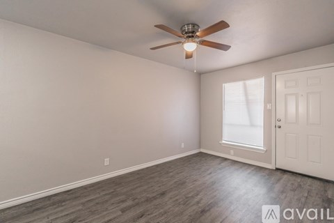 A room with a ceiling fan and a door.
