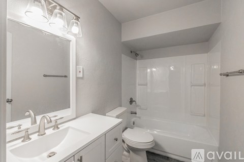 A white bathroom with a sink, toilet, and bathtub.