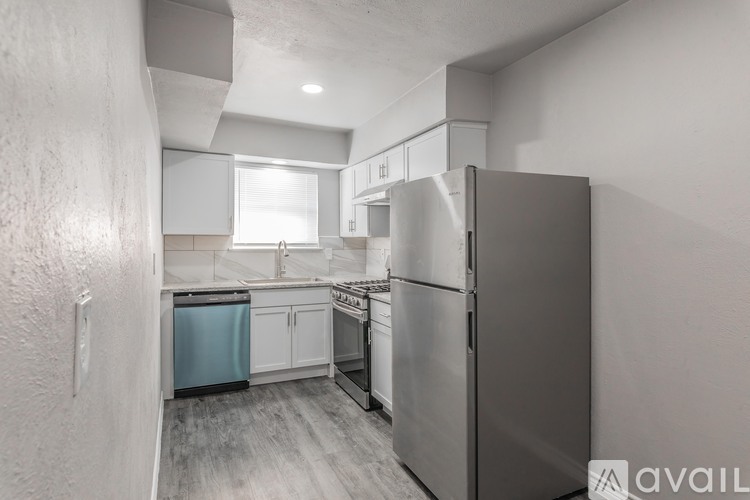 A kitchen with a refrigerator, oven, and sink.