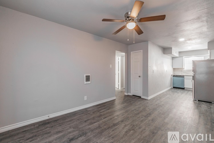 A room with a ceiling fan and wooden flooring.