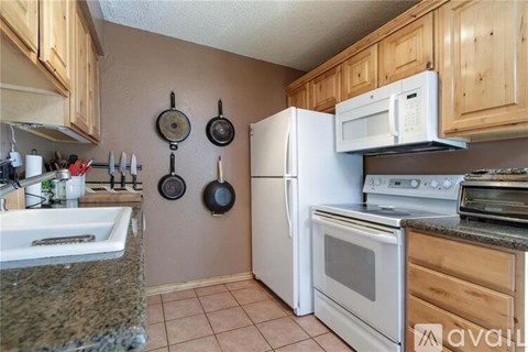 A kitchen with a white refrigerator, a microwave, and a stove.
