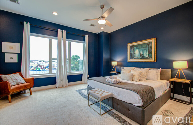A bedroom with a large bed and a ceiling fan.