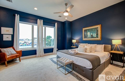 A bedroom with a large bed and a ceiling fan.