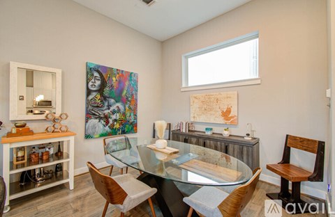 A dining room with a glass table and chairs.