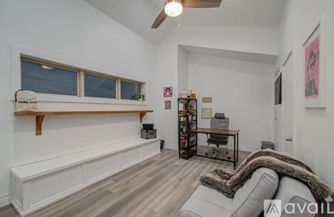 A living room with a grey couch and a wooden shelf.