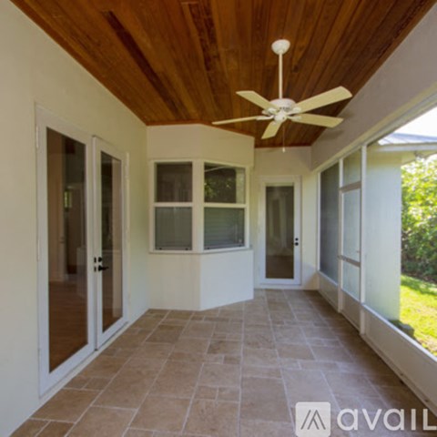 A patio with a ceiling fan and tiled floor.