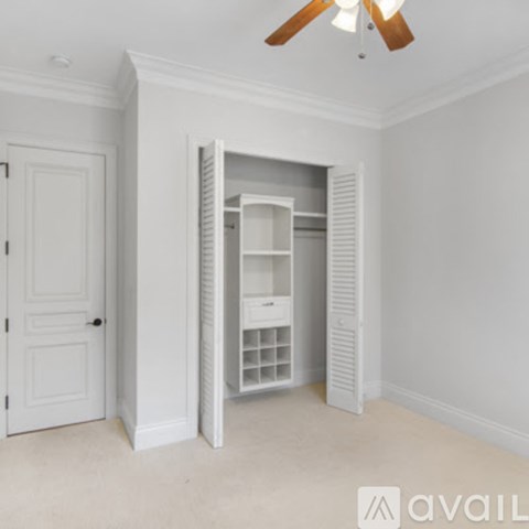 A room with a white door and a white shelving unit.