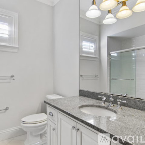 A white toilet sits next to a sink in a bathroom.