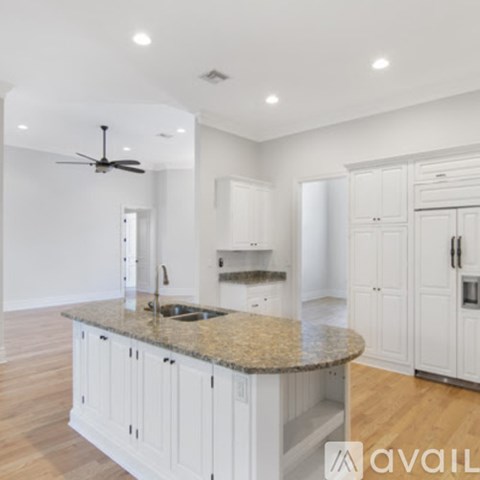 A kitchen with white cabinets and a granite countertop.