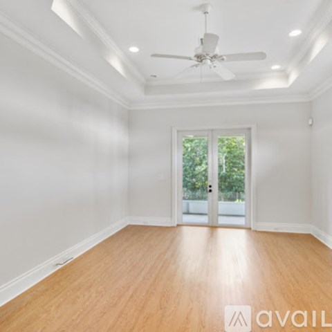 A room with a ceiling fan and wooden flooring.
