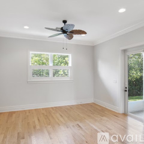 A room with a ceiling fan and wooden flooring.