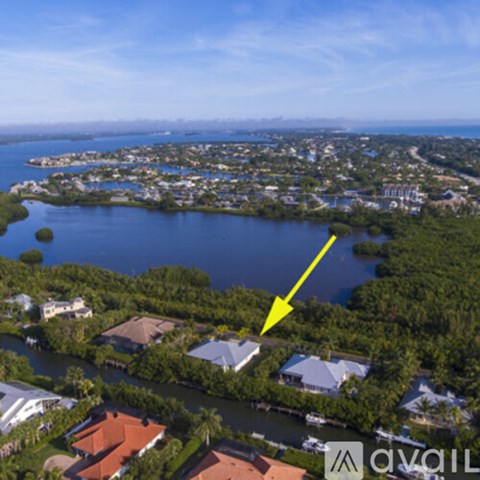 A yellow arrow points to a house in a lush green area.
