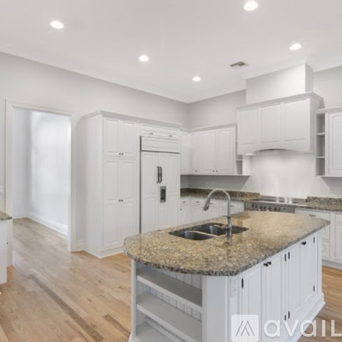 A kitchen with a granite countertop and white cabinets.