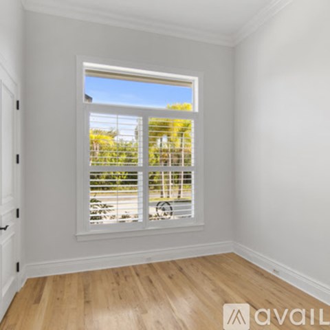 A room with a window overlooking a parking lot.