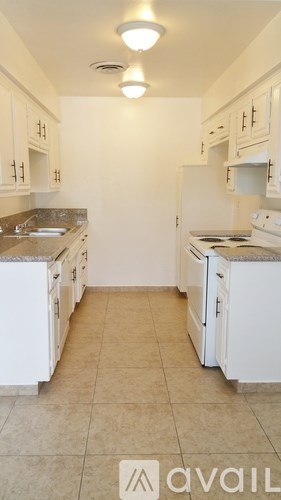 A kitchen with white appliances and cabinets.