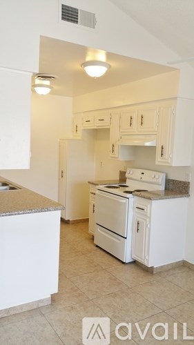 A kitchen with white appliances and cabinets.