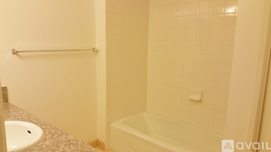 A bathroom with a tub, sink and a towel rack.