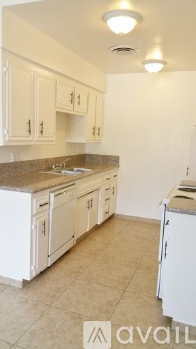A kitchen with white cabinets and a granite countertop.