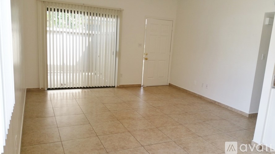 A room with a tiled floor and a window with blinds.