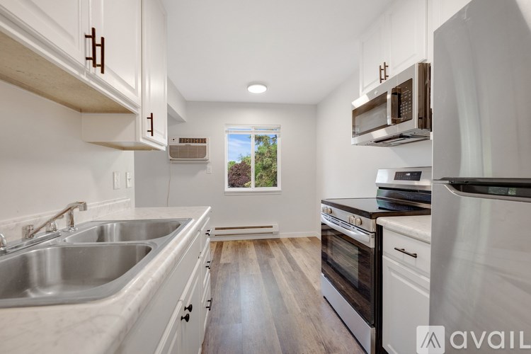 A kitchen with white cabinets and a stainless steel sink.