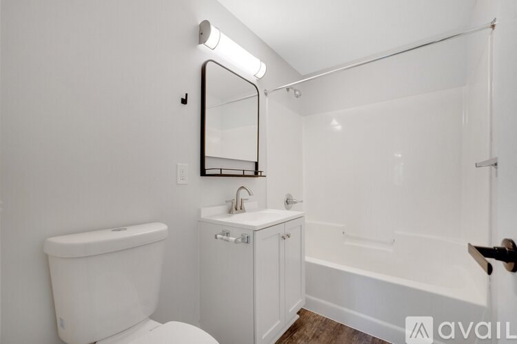 A white bathroom with a toilet, sink, and bathtub.