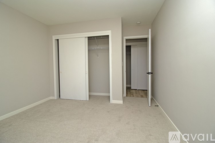 A room with a carpeted floor and two open doors.