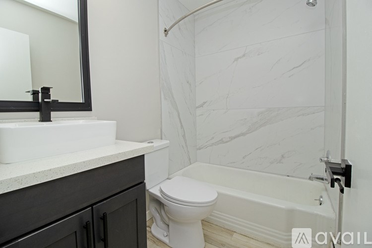 A bathroom with a white toilet and a white bathtub.