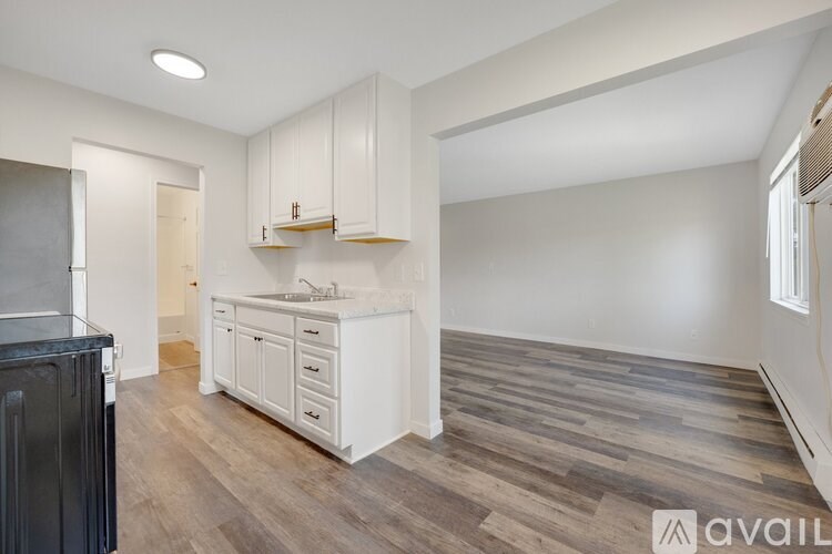 A kitchen with white cabinets and a black countertop.